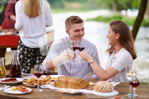 Image of friends having picnic french dinner party outdoor during summer holiday