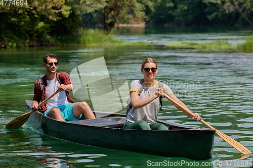 Image of friends are canoeing in a wild river