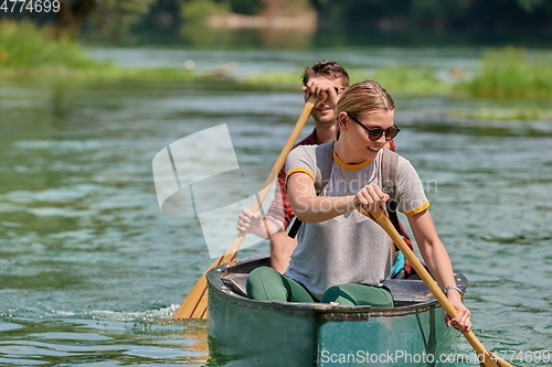 Image of friends are canoeing in a wild river