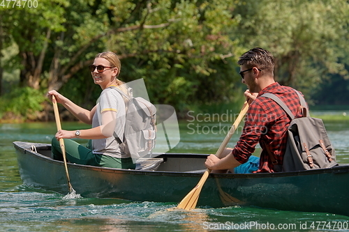 Image of friends are canoeing in a wild river