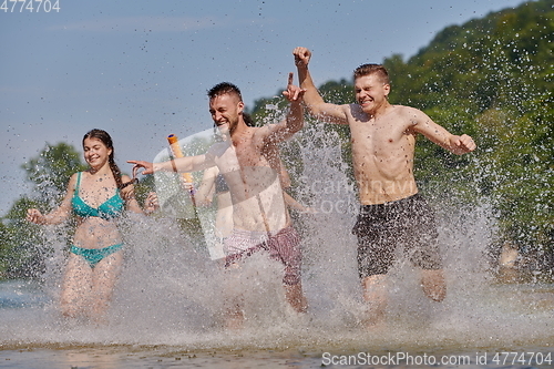 Image of group of happy friends having fun on river