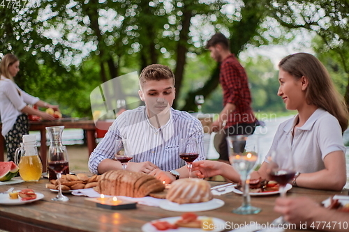 Image of friends having picnic french dinner party outdoor during summer holiday