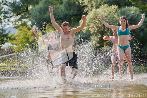 Image of group of happy friends having fun on river