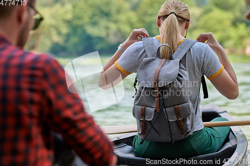 Image of friends are canoeing in a wild river