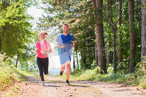 Image of couple enjoying in a healthy lifestyle while jogging on a country road