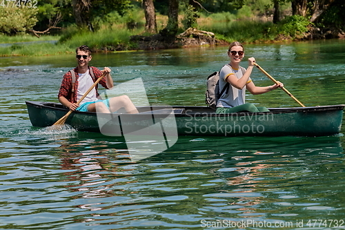 Image of friends are canoeing in a wild river