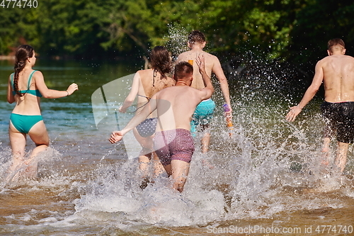 Image of group of happy friends having fun on river