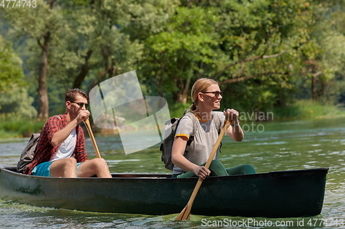 Image of friends are canoeing in a wild river