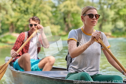 Image of friends are canoeing in a wild river