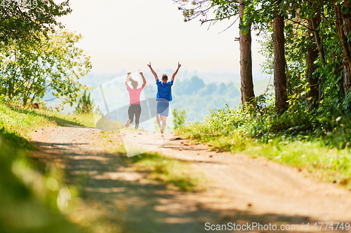 Image of couple enjoying in a healthy lifestyle while jogging on a country road