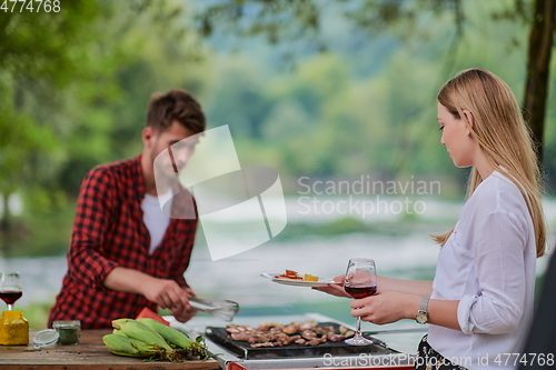 Image of friends having picnic french dinner party outdoor during summer holiday