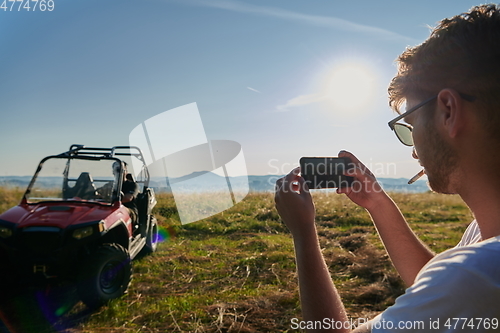 Image of cameraman recording a young couple enjoying a buggy car ride up a mountain