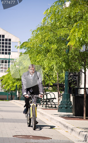 Image of Caucasian businessman riding a bicycle