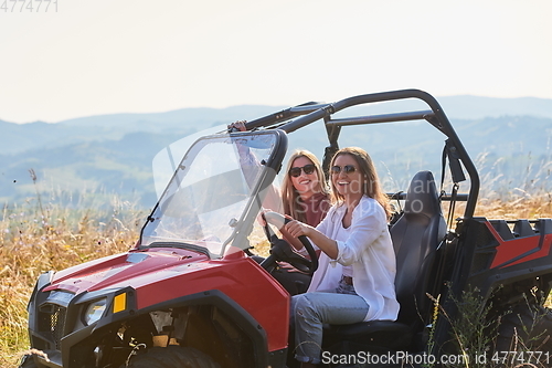 Image of girls enjoying a beautiful sunny day while driving an off-road car