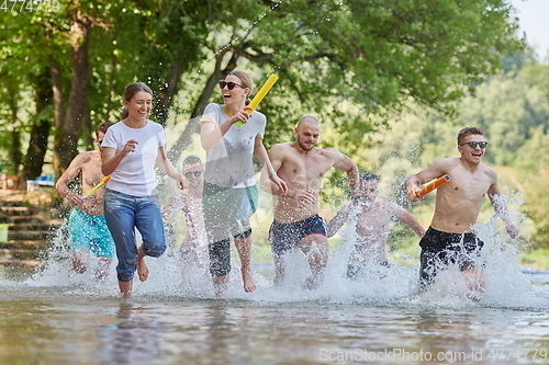 Image of group of happy friends having fun on river