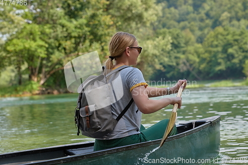 Image of woman adventurous explorer are canoeing in a wild river