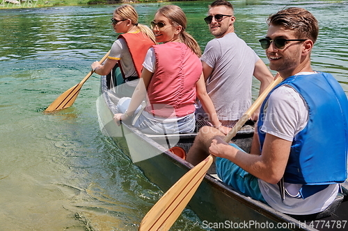 Image of Group adventurous explorer friends are canoeing in a wild river