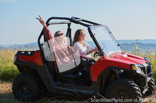 Image of girls enjoying a beautiful sunny day while driving an off-road car