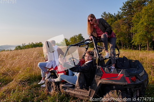 Image of group young happy people enjoying beautiful sunny day while driving a off road buggy car