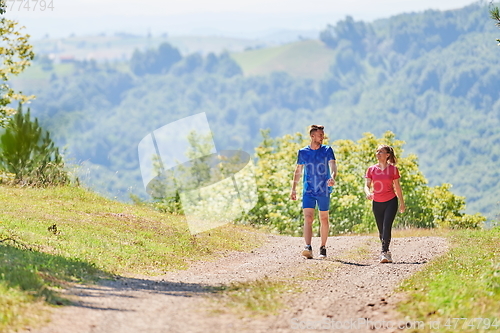 Image of couple enjoying in a healthy lifestyle while jogging on a country road