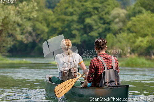 Image of friends are canoeing in a wild river