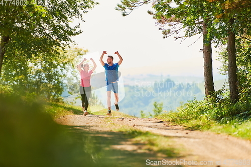 Image of couple enjoying in a healthy lifestyle while jogging on a country road