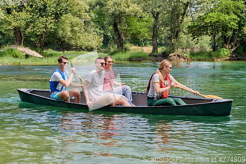 Image of Group adventurous explorer friends are canoeing in a wild river