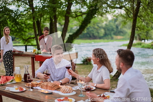 Image of friends having picnic french dinner party outdoor during summer holiday