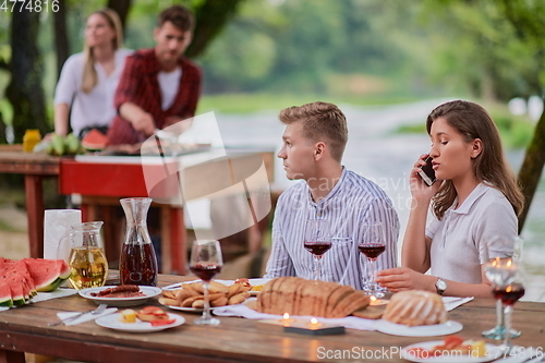 Image of friends having picnic french dinner party outdoor during summer holiday
