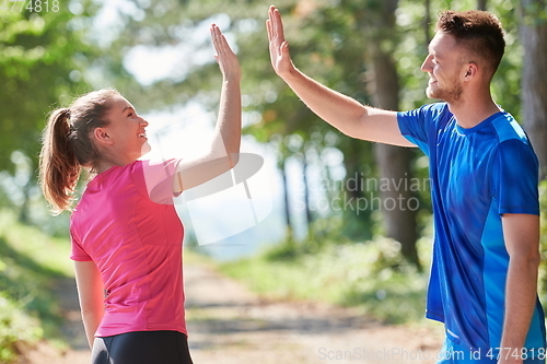 Image of couple enjoying in a healthy lifestyle while jogging on a country road