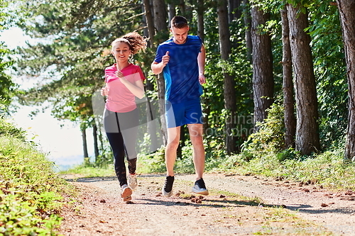 Image of couple enjoying in a healthy lifestyle while jogging on a country road