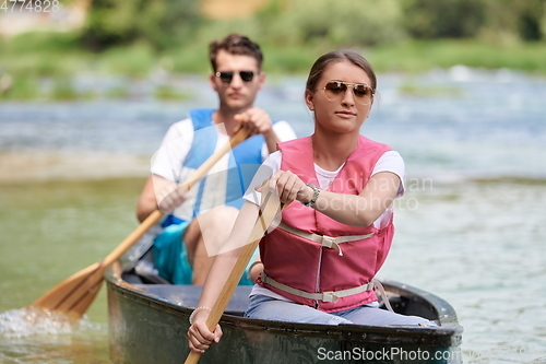 Image of friends are canoeing in a wild river