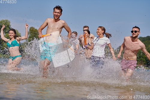 Image of group of happy friends having fun on river