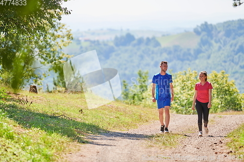 Image of couple enjoying in a healthy lifestyle while jogging on a country road