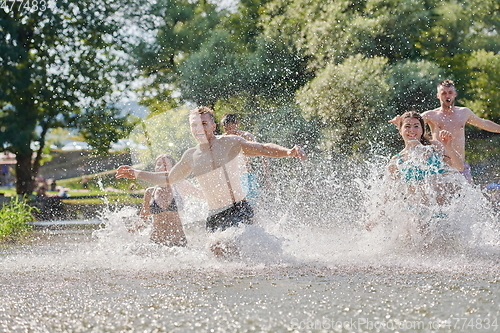 Image of group of happy friends having fun on river