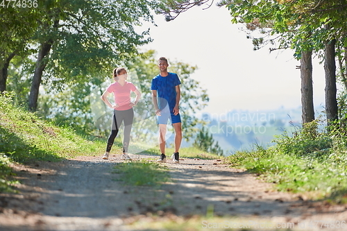 Image of couple enjoying in a healthy lifestyle while jogging on a country road