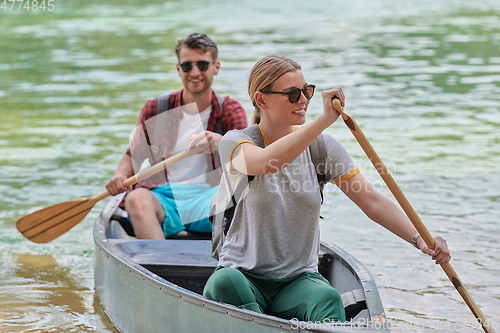 Image of friends are canoeing in a wild river