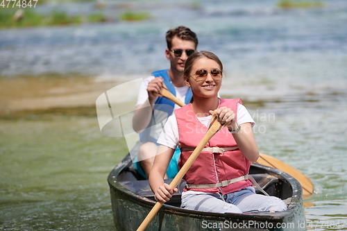 Image of friends are canoeing in a wild river