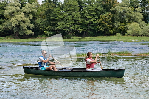 Image of friends are canoeing in a wild river