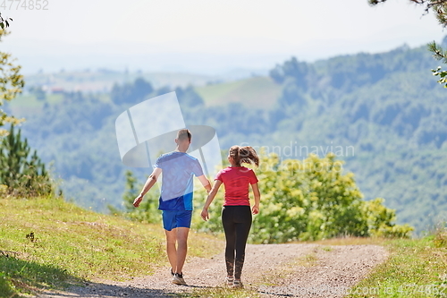 Image of couple enjoying in a healthy lifestyle while jogging on a country road