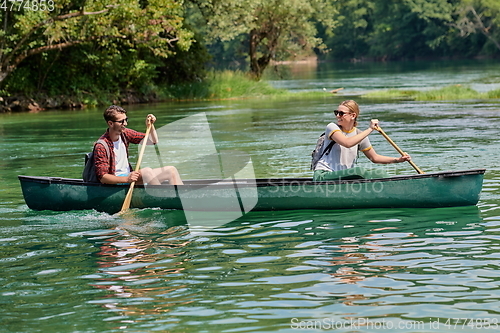 Image of friends are canoeing in a wild river