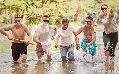 Image of group of happy friends having fun on river