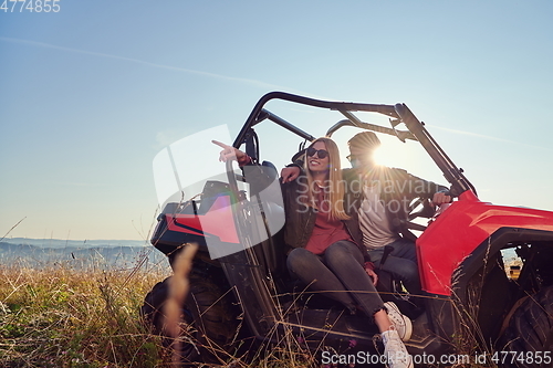 Image of couple enjoying beautiful sunny day while driving a off road buggy