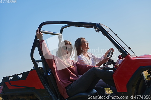 Image of girls enjoying a beautiful sunny day while driving an off-road car