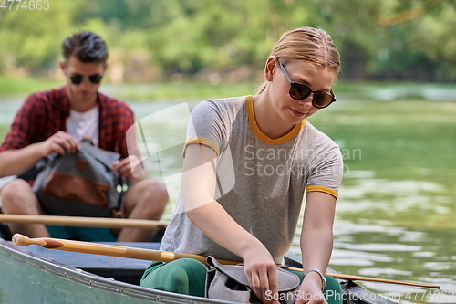 Image of friends are canoeing in a wild river