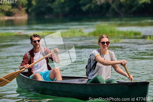 Image of friends are canoeing in a wild river