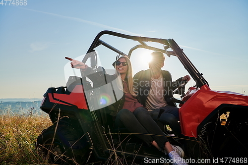 Image of couple enjoying beautiful sunny day while driving a off road buggy