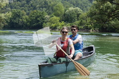 Image of friends are canoeing in a wild river