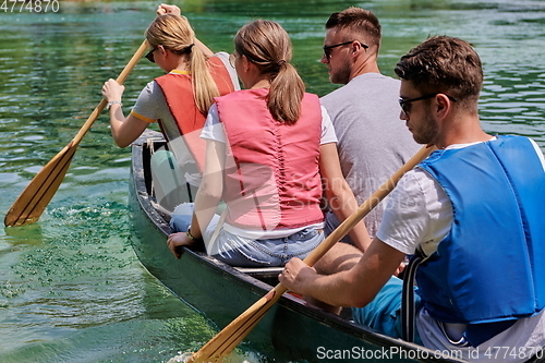 Image of Group adventurous explorer friends are canoeing in a wild river