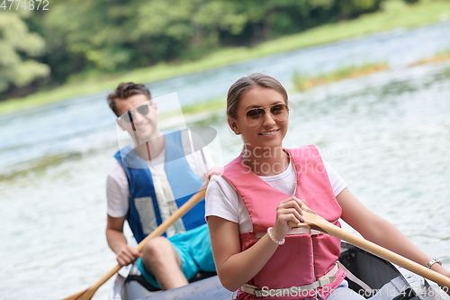 Image of friends are canoeing in a wild river